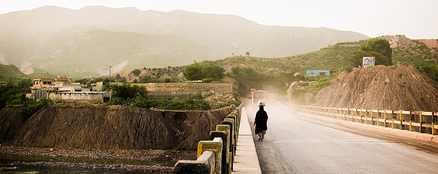 A woman crosses a bridge in a rural area of Pakistan [Pixabay]